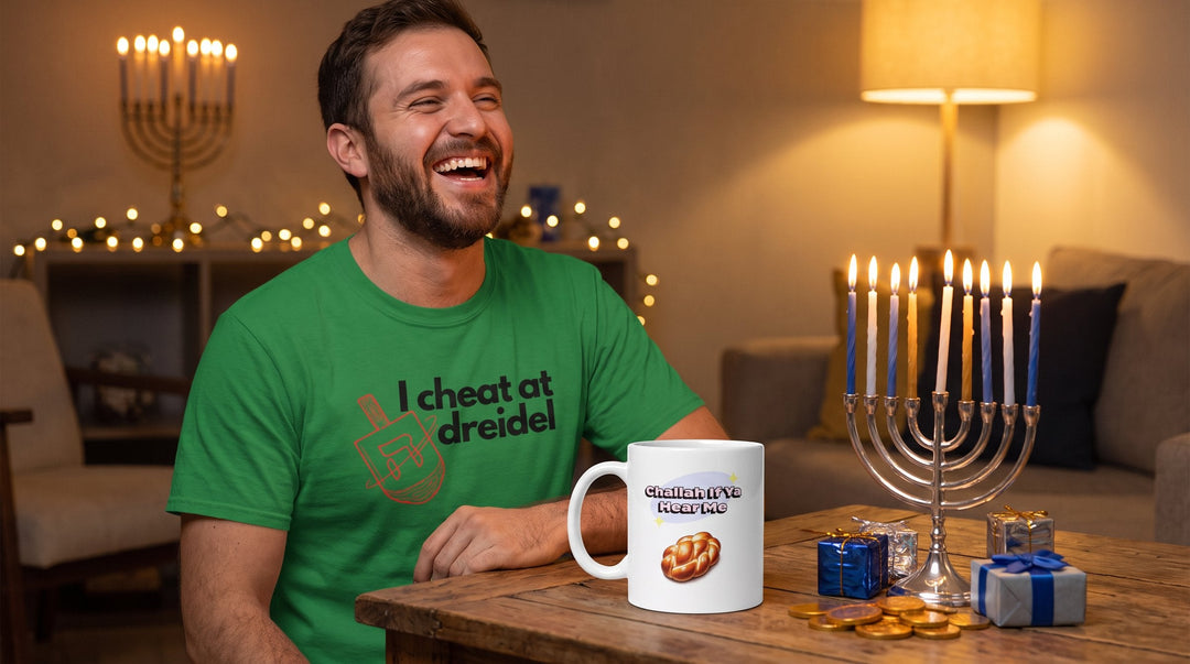 Man in the I Cheat At Dreidel Jewish tee with the Challah mug, a lit hanukkiah and Hanukkah gifts