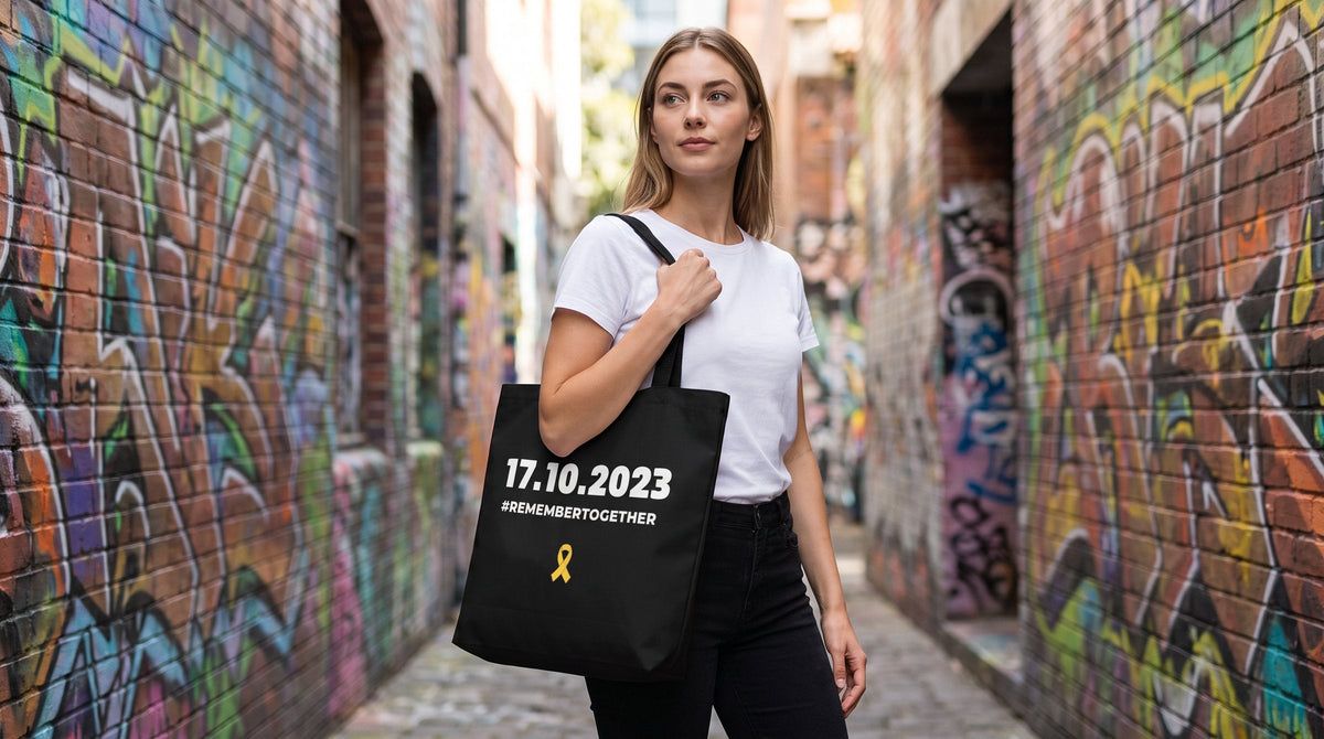 Woman carrying the 07.10.2023 Remember Together tote bag - emohtee remembrance collection