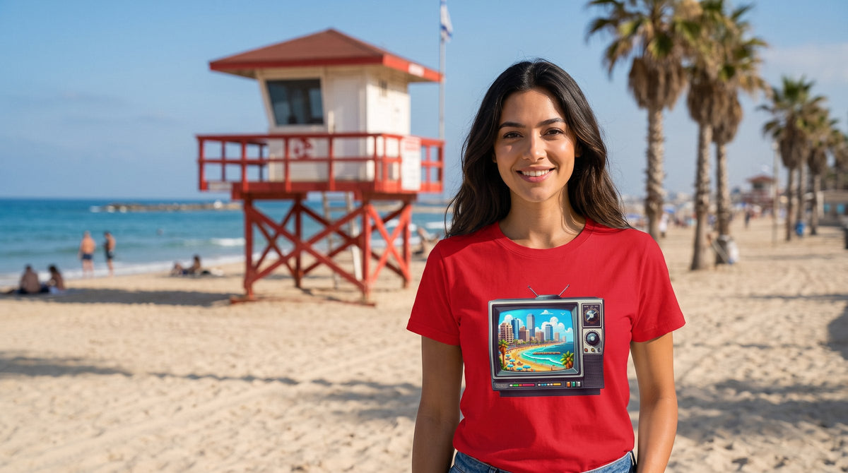 16 Bit Tel Aviv Beach T-shirt worn by a woman on a Tel Aviv beach with lifeguard tower – MoT Member of the Tribe