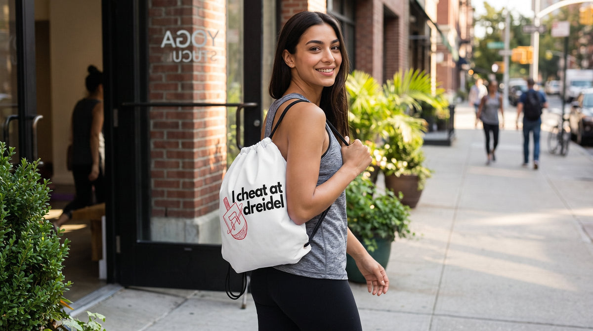 Woman carrying the I Cheat At Dreidel drawstring bag - emohtee drawstring bags