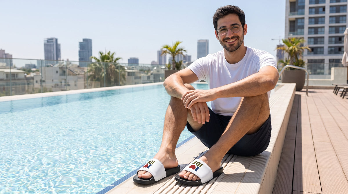 Man wearing I Love IDF slides by a rooftop pool - emohtee flip flops and slides