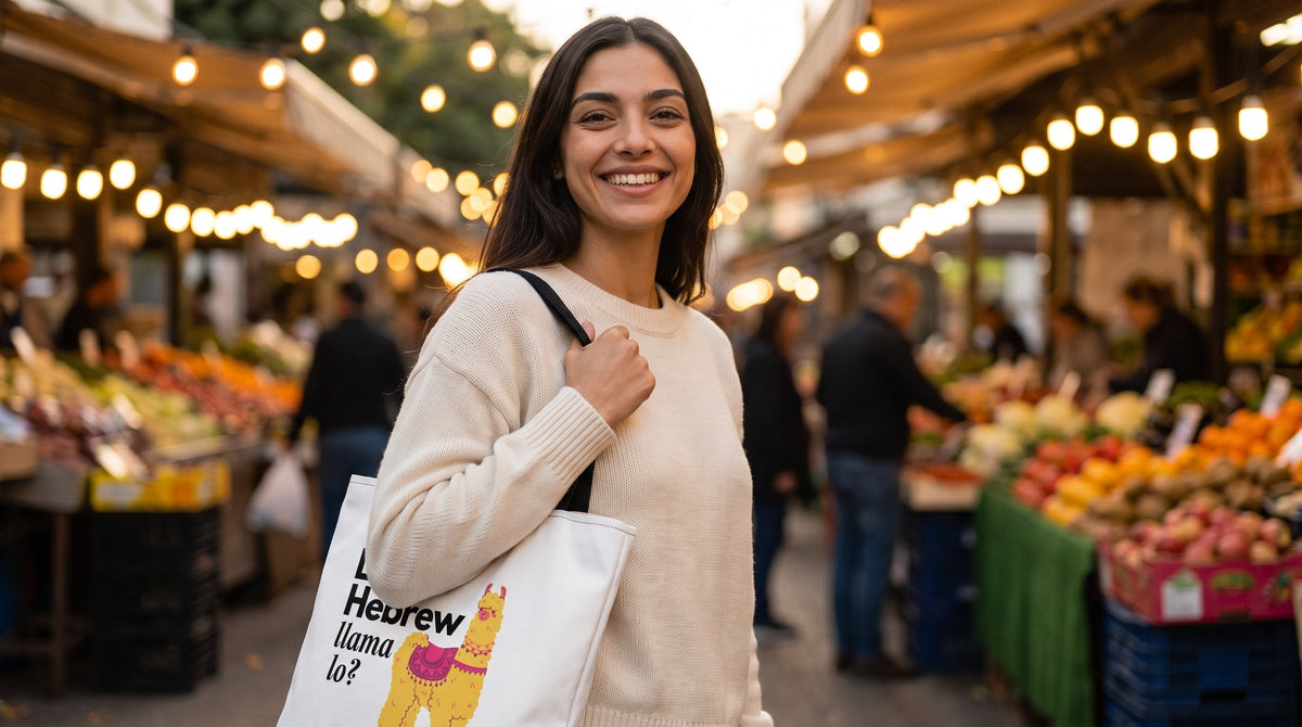 Woman carrying the Learn Hebrew Llama Lo tote bag at Sarona Market - emohtee tote bags