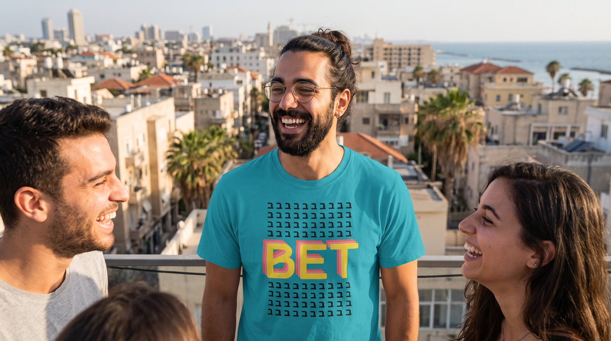 Bet ב T-shirt worn by a man on a rooftop terrace above the Tel Aviv skyline – MoT Member of the Tribe
