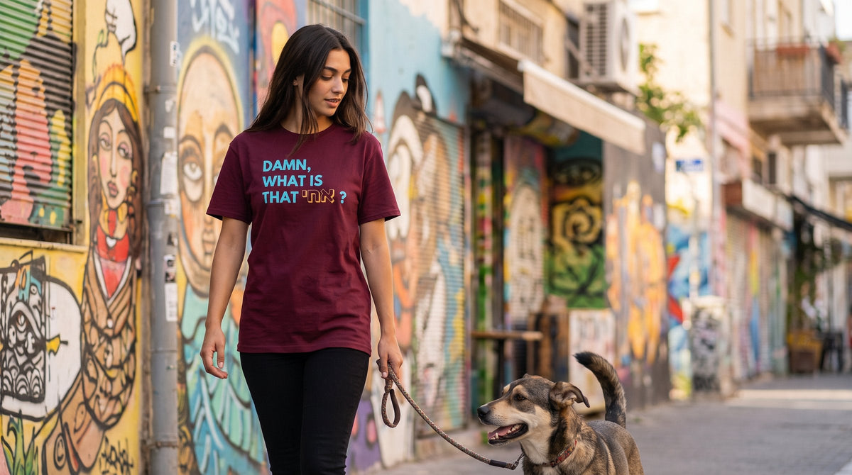 Damn What Is That אחי cap worn by a woman in a colourful Florentin street with street art in Tel Aviv – MoT Member of the Tribe