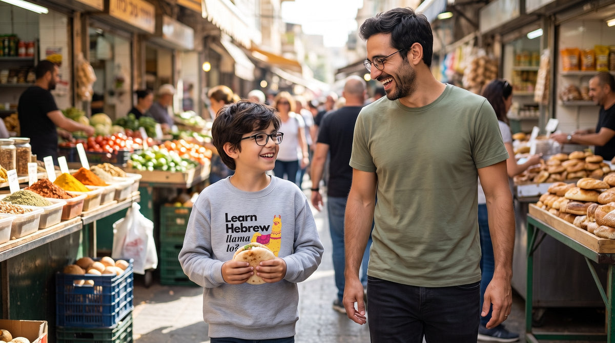 Boy in the Learn Hebrew Llama Lo youth sweatshirt with his father at Carmel Market - emohtee Jewish kids clothing
