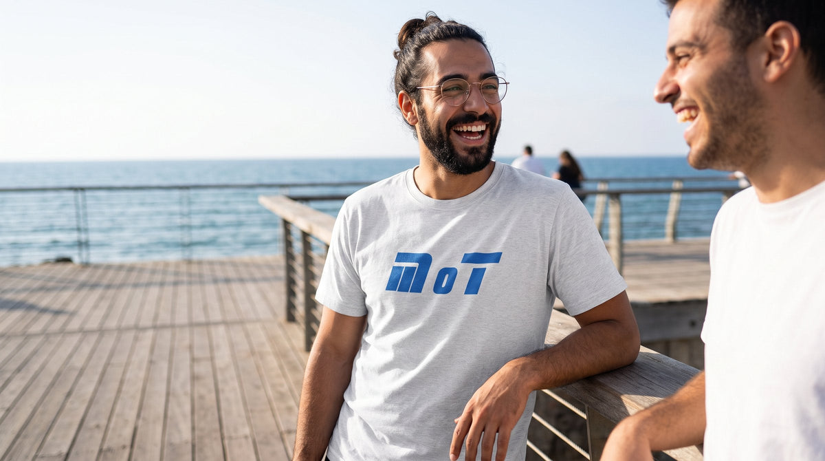 MOT T-shirt worn by a man on a seaside boardwalk in Tel Aviv – MoT Member of the Tribe