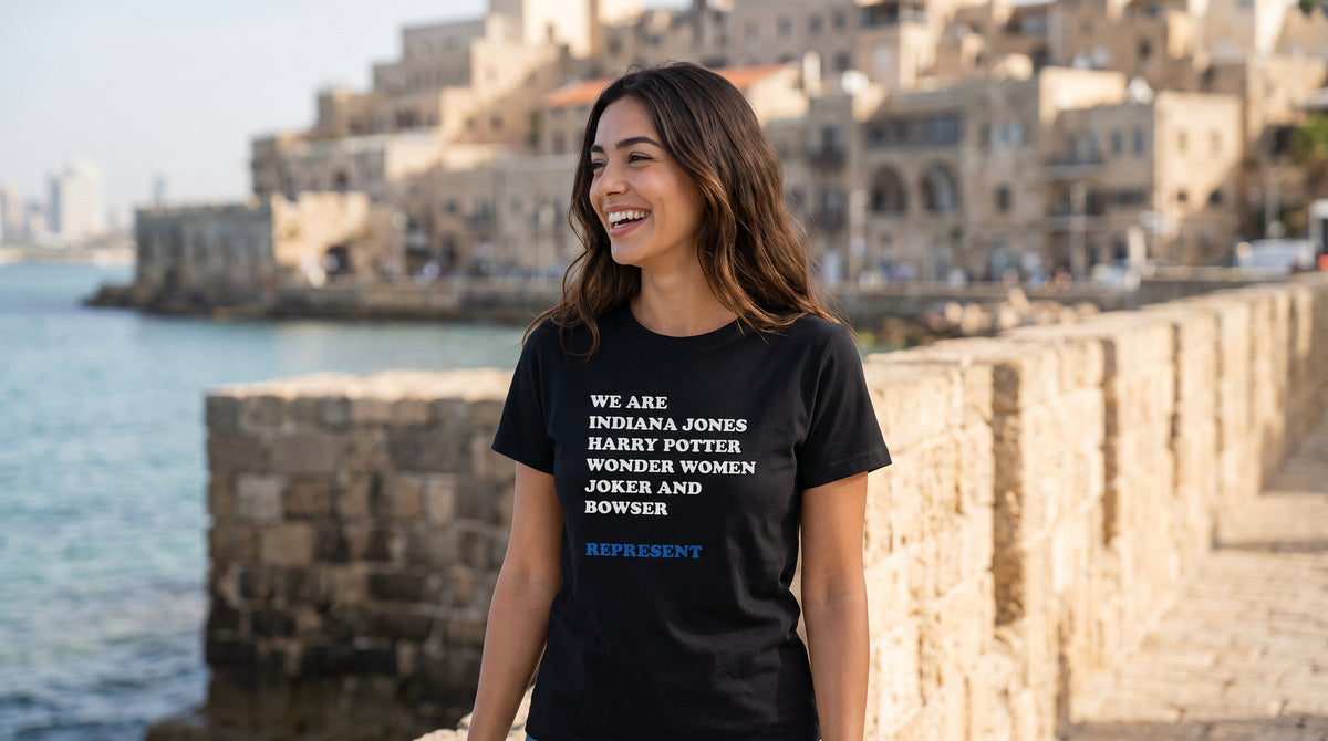 We are Iconic Roles 1 T-shirt worn by a woman on the old sea wall of Jaffa port – MoT Member of the Tribe