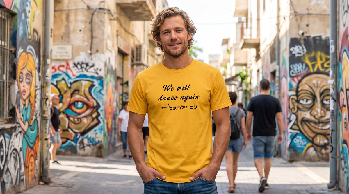 We will dance again T-shirt worn by a man in a colourful Florentin street with street art in Tel Aviv – MoT Member of the Tribe