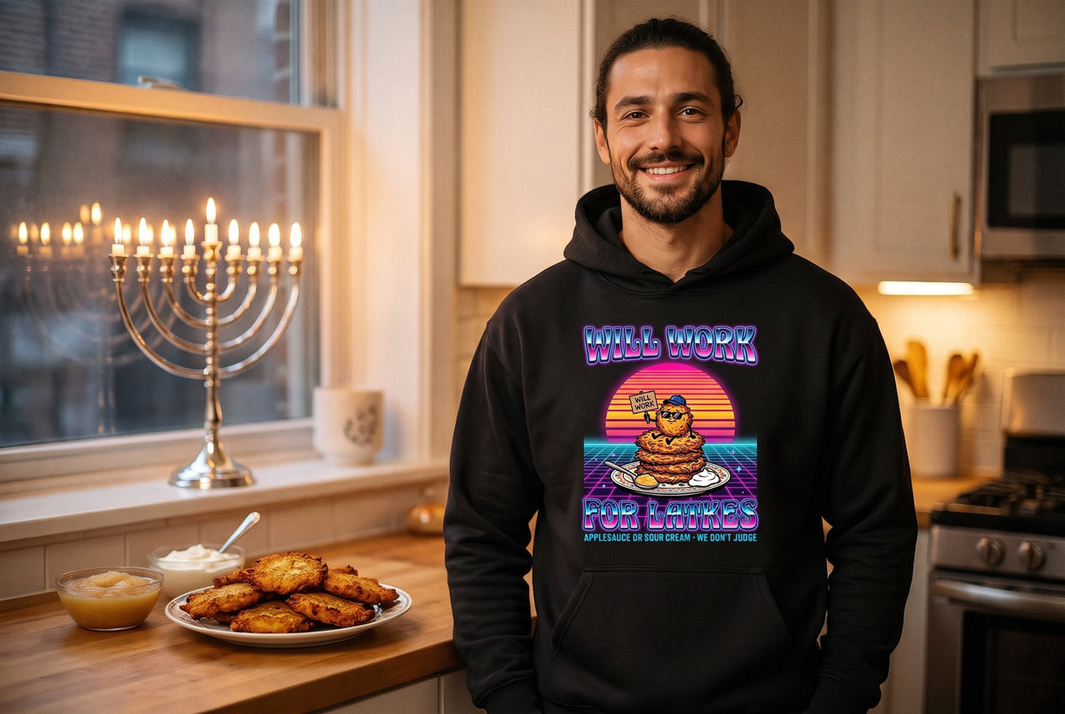 Will Work for Latkes 80s hoodie worn by a man in a cozy kitchen with a lit Hanukkah menorah and latkes – MoT Member of the Tribe