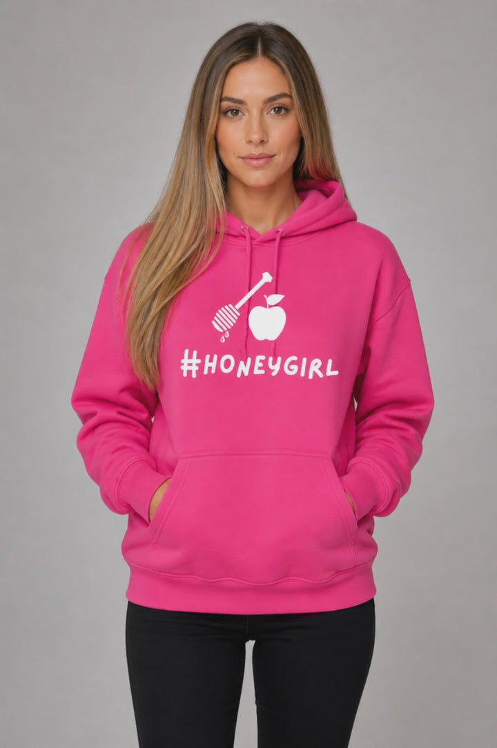 Woman wearing a pink Honeygirl hoodie with honey dipper and apple, Rosh Hashanah apparel